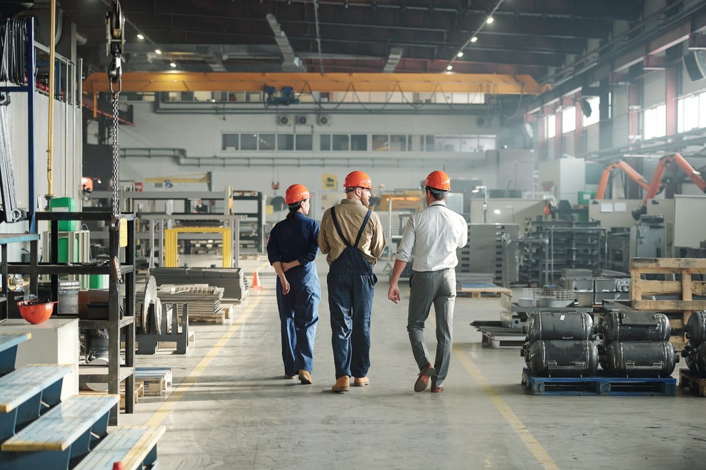 Workers walking through a manufacturing plant floor