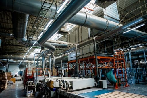 Modern manufacturing facility interior with piping and equipment