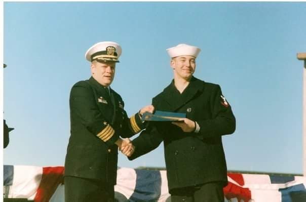 A young Paul Swaney in Navy dress uniform receiving an award